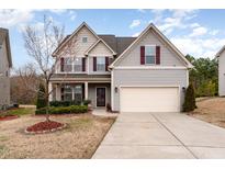 Charming two-story home with vinyl siding, mature landscaping, and a two-car garage at 410 Pintail Ct, Durham, NC 27704