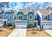 Charming two-story home with vibrant turquoise siding, white trim, and a well-maintained front yard at 424 Hopwood Way, Apex, NC 27523