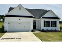 Charming single-story home with white siding, a two-car garage, and well-maintained landscaping at 472 Springtooth Dr, Zebulon, NC 27597