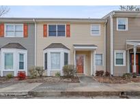 Charming townhouse featuring neutral siding, updated windows, and manicured landscaping at 519 Darby Glen Ln, Durham, NC 27713
