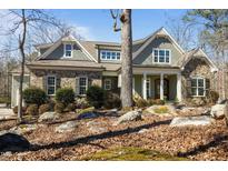 Charming two-story home with stone and shingle accents, a covered porch, and a natural, wooded setting at 56 Clarence Ln, Pittsboro, NC 27312
