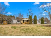 Charming single-story home features a covered front porch and well-maintained yard with mature trees at 5636 Thom Rd, Mebane, NC 27302