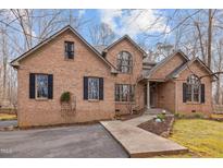 Charming brick home featuring a symmetrical design, arched windows, and a well-maintained front yard at 6106 Bent Oak Dr, Durham, NC 27705