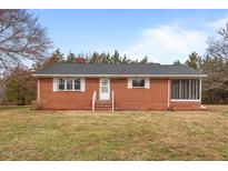 Charming brick home featuring a screened-in porch and well-maintained lawn at 7415 Old Oxford Rd, Bahama, NC 27503
