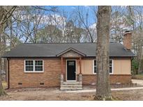 Charming brick home featuring a well-manicured lawn, inviting entrance, and an idyllic suburban setting at 7725 Longstreet Dr, Raleigh, NC 27615