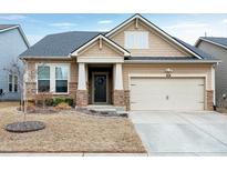 Charming one-story home featuring stone accents, a welcoming front porch, and an attached garage at 823 Atticus Way, Durham, NC 27703