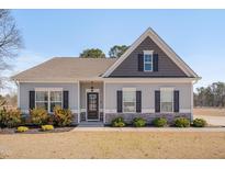 Charming single-story home with gray siding, stone accents, and a well-manicured front yard at 84 Nonabell Ln, Four Oaks, NC 27524