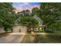Charming two-story home with a manicured lawn, mature trees, and a welcoming front porch at 94 Fawn Hill Ct, Garner, NC 27529