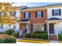 Charming brick townhouse with black shutters and a well-manicured front yard at 1707 Stroll Cir, Fuquay Varina, NC 27526