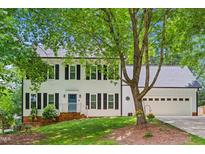 Charming two-story home with a lush lawn, two-car garage, and a bright blue front door at 2006 Chedington Dr, Apex, NC 27502