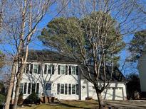 Traditional two-story home boasting white siding, black shutters, attached two-car garage, and landscaped front yard at 2006 Chedington Dr, Apex, NC 27502