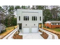 Contemporary home featuring a two-car garage, modern windows, and a landscaped yard with driveway and mulch at 2730 Milburnie Rd, Raleigh, NC 27610