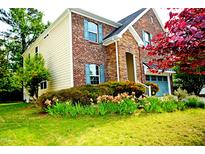 Beautiful brick and stone home featuring lovely landscaping and blue shutters at 3614 Kilgo Dr, Durham, NC 27705