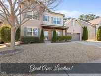 Charming two-story home featuring a welcoming front porch, a two car garage, and manicured landscaping at 3621 Colby Chase Dr, Apex, NC 27539
