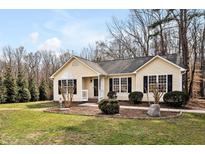 Charming single-story home featuring a manicured lawn, black shutters and a welcoming front porch at 410 Foxcroft Dr, Timberlake, NC 27583