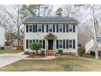 Charming two-story home featuring black shutters, a well-maintained lawn, and mature trees at 4819 Lazyriver Dr, Durham, NC 27712