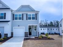 Charming two-story home featuring blue siding, a one-car garage, and manicured landscaping at 4914 Arkose Dr, Raleigh, NC 27610