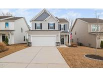 Charming two-story home with a well-manicured lawn and a two-car garage in a suburban neighborhood at 555 Whitley Rdg Dr, Clayton, NC 27527