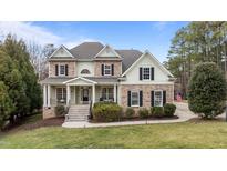 Charming two-story home with stone accents, a welcoming front porch, and professionally landscaped yard at 7709 Moondance Ct, Wake Forest, NC 27587