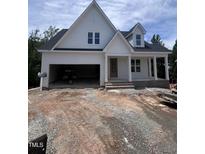 New construction home featuring a charming facade, inviting front porch, and an attached two-car garage at 108 Pointe Park Cir, Holly Springs, NC 27540