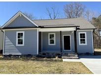 Charming single-story home with a covered porch, gray siding, and a well-manicured front yard at 119 Daniel St, Oxford, NC 27565