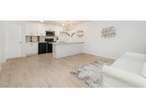 Bright kitchen with white cabinetry, black appliances, and a modern chandelier at 130 S Estes Dr # F6, Chapel Hill, NC 27514