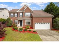 Charming two-story brick home featuring a well-manicured lawn and attached two car garage at 2017 Ollivander Dr, Cary, NC 27519