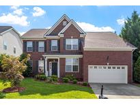 Charming two-story brick home with manicured lawn and attached two-car garage at 2017 Ollivander Dr, Cary, NC 27519