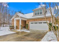Charming home with a stone facade, complemented by a well-manicured lawn and a two-car garage during winter at 208 Abigail Ln, Gibsonville, NC 27249