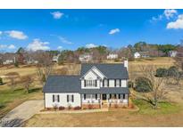 Inviting two-story home with a charming front porch and well-maintained landscaping at 212 Riverwood Dr, Clayton, NC 27527
