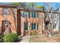 Brick townhome featuring green shutters and a well-maintained front lawn at 3213 Coachmans Way, Durham, NC 27705