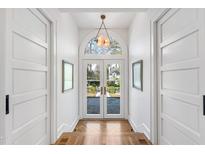 Elegant entryway featuring herringbone floors, white doors, and a beautiful arched transom window at 330 Tenney Circle, Chapel Hill, NC 27514