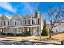 Charming townhome featuring a covered front porch, neutral siding, and black shutters, set against a bright blue sky at 3931 Volkswalk Pl, Raleigh, NC 27610