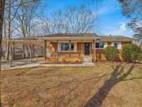 Charming single-story brick home featuring a covered carport, covered front porch, and a well-maintained lawn at 427 Watson Rd, Efland, NC 27243