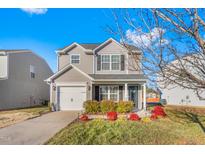 Charming two-story home features a well-maintained front yard with vibrant landscaping and a one-car garage at 642 Thistle Dr, Burlington, NC 27217
