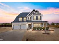 Charming two-story home featuring a manicured lawn, attached three-car garage and welcoming covered porch at 6804 Arlington Oaks Trl, Raleigh, NC 27603