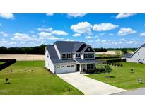 Charming two-story home boasts a two-car garage and welcoming front porch, nestled on a spacious lawn with mature landscaping at 6804 Arlington Oaks Trl, Raleigh, NC 27603