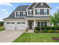 Beautiful two-story home featuring a two-car garage, charming front porch, and manicured landscaping at 6804 Arlington Oaks Trl, Raleigh, NC 27603