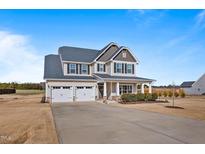 Charming two-story home with a two-car garage, covered porch, landscaped yard, and neutral siding at 6804 Arlington Oaks Trl, Raleigh, NC 27603