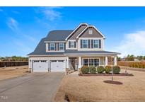 Charming two-story home featuring a two-car garage, manicured lawn, and inviting front porch at 6804 Arlington Oaks Trl, Raleigh, NC 27603