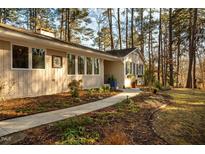 Inviting one-story home with a charming landscaped front yard and pathway to the front door at 708 Kenmore Rd, Chapel Hill, NC 27514