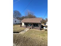 Charming single-story home featuring a cozy covered front porch with seating and a well-maintained yard at 835 N Beckford Dr, Henderson, NC 27536