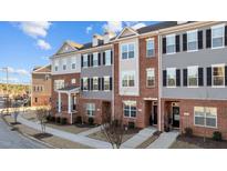 Charming townhomes with brick and siding, black shutters, dormers, and well-maintained landscaping at 978 Gateway Commons Cir, Wake Forest, NC 27587