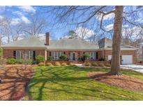 Beautiful brick home featuring manicured lawn and mature trees at 105 Wicklow Pl, Chapel Hill, NC 27517