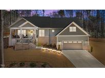 Charming single-Gathering home featuring a covered front porch and an attached two-car garage at 112 Rawhide Dr, Louisburg, NC 27549