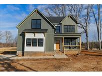 Beautiful two-story home featuring green and white siding, black framed windows, and a charming front porch at 1403 Antioch Church Rd, Timberlake, NC 27583