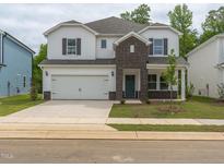 Charming two-story home featuring a brick facade, attached garage, and a well-maintained lawn at 2114 Cherry Creek Rd, Haw River, NC 27258