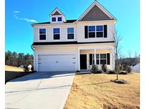 Charming two-story home with a two car garage and a well-manicured lawn under a clear blue sky at 265 Forest Meadow Ln, Franklinton, NC 27525