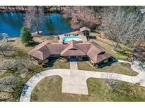 An aerial view of the stunning lakefront home with a pool and a spacious driveway at 3021 Allenby Dr, Raleigh, NC 27604
