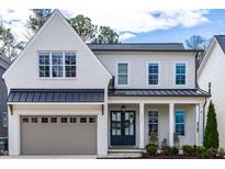 Charming two-story home features a front-facing garage, a covered porch, and eye-catching architectural details at 3037 Eden Harbor Ct, Raleigh, NC 27613
